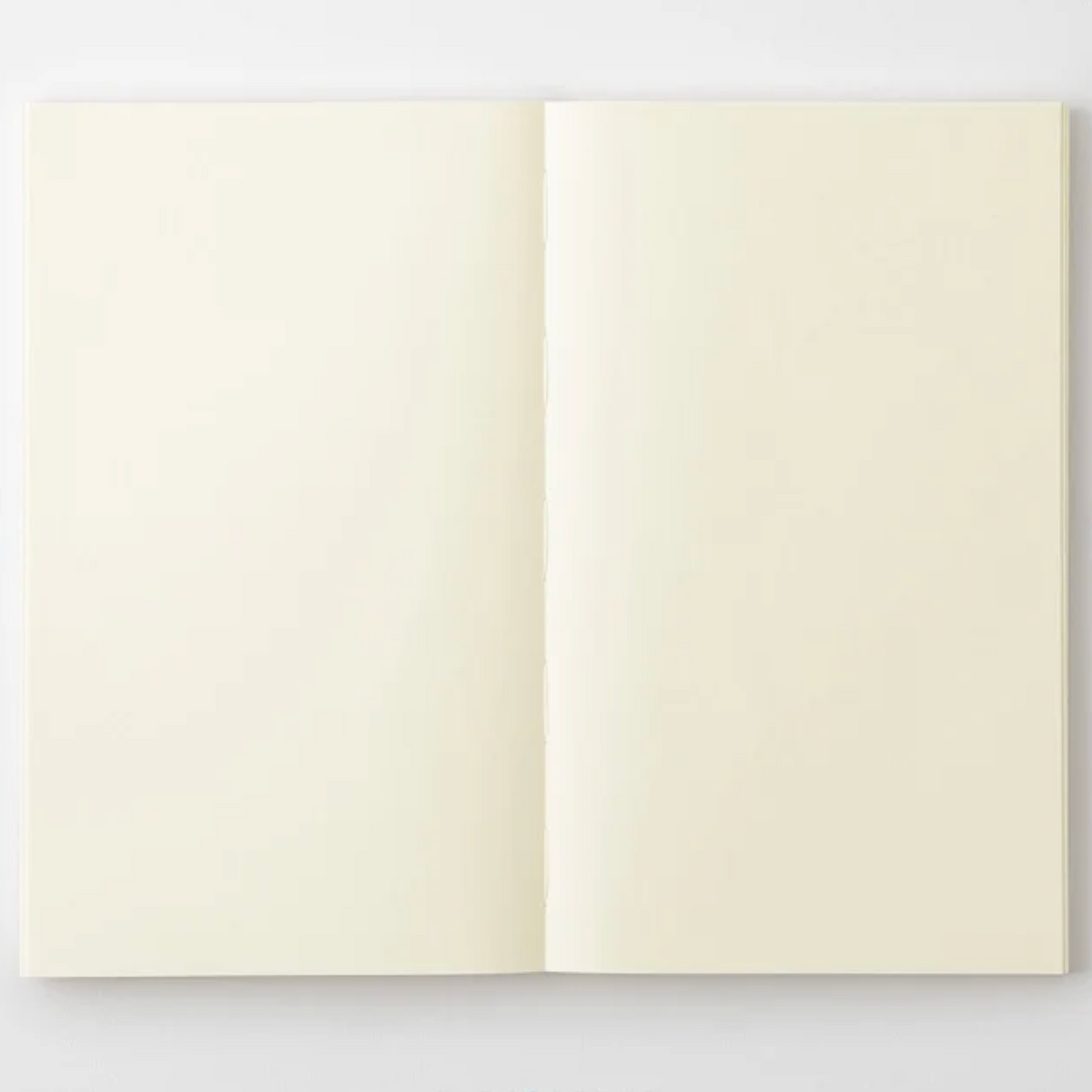 An open notebook with blank, warm cream-colored pages, displayed flat against a clean white background.