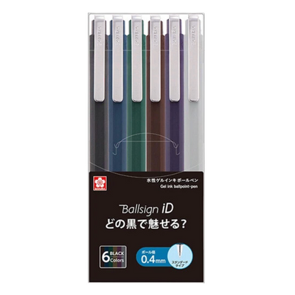 A 6-pack of Sakura Pigma Ballsign iD gel ink ballpoint pens in various colors, packaged in a clear plastic case with a black and white background.