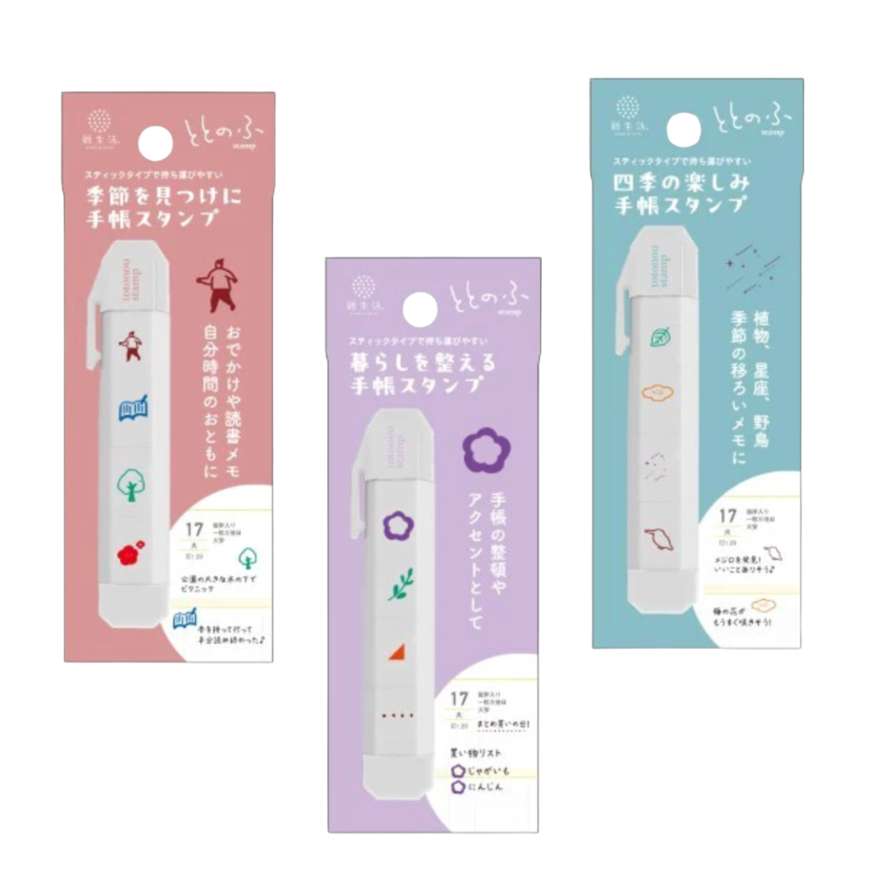 Three packages of a white clip-style hand stamp tool shown together on a white background, each in a different pastel color scheme: pink, lavender, and light blue. The packages contain Japanese text and small printed icons on a white background.