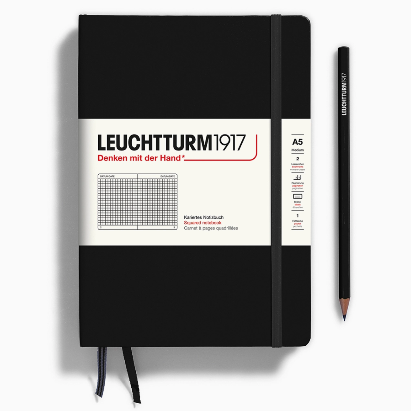 Black notebook with white label and pen on a white background
