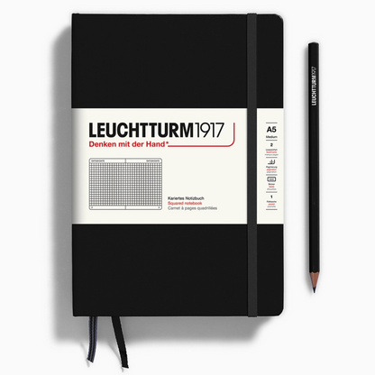 Black notebook with white label and pen on a white background