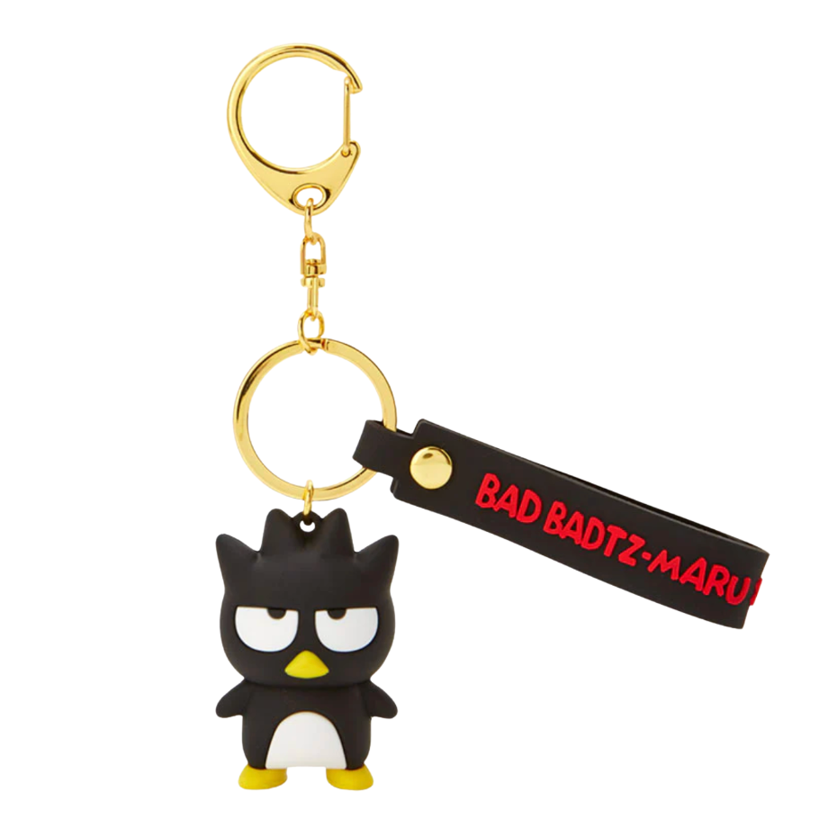 Keychain with a black and white character and gold ring on a white background
