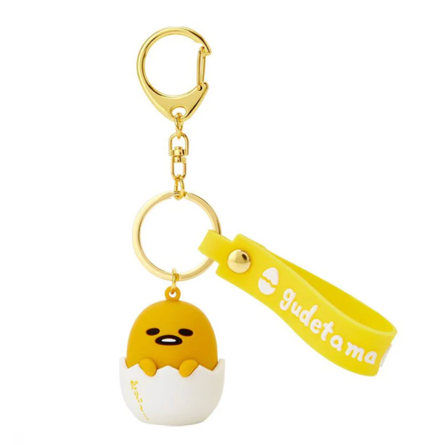 Keychain with a cartoon character in an egg and a yellow tag with 'Gudetama' text on a white background