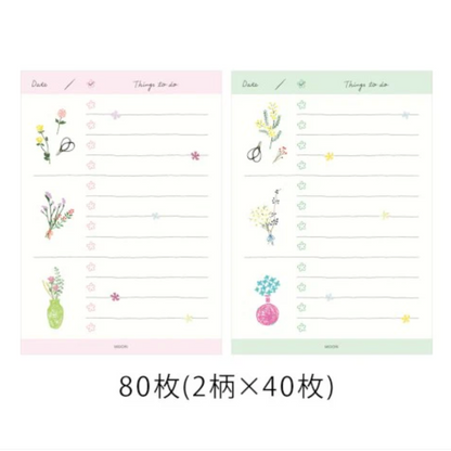 Two sheets of lined paper with floral designs on a white background