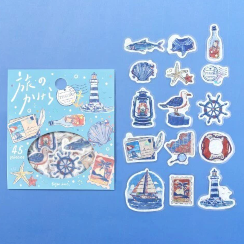 Nautical-themed sticker set featuring a light blue card with illustrations of a lighthouse, ship wheel, seashells, starfish, and postcards, alongside 15 individual die-cut stickers on a solid blue background.