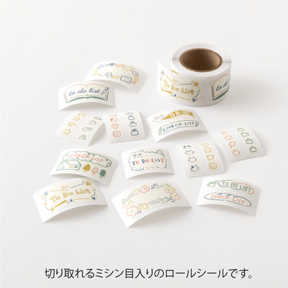 A roll of decorative adhesive stickers with French phrases and small doodles, shown with several individual sticker sheets scattered on a white background. Japanese text appears below the product photo.
