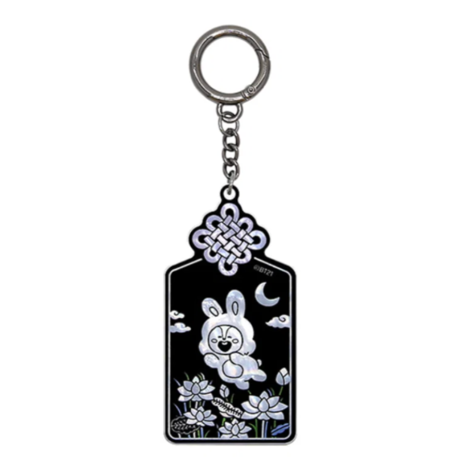 A black and silver keychain featuring a white cartoon bunny, a crescent moon, clouds, and floral details, suspended from a silver metal ring on a plain white background.