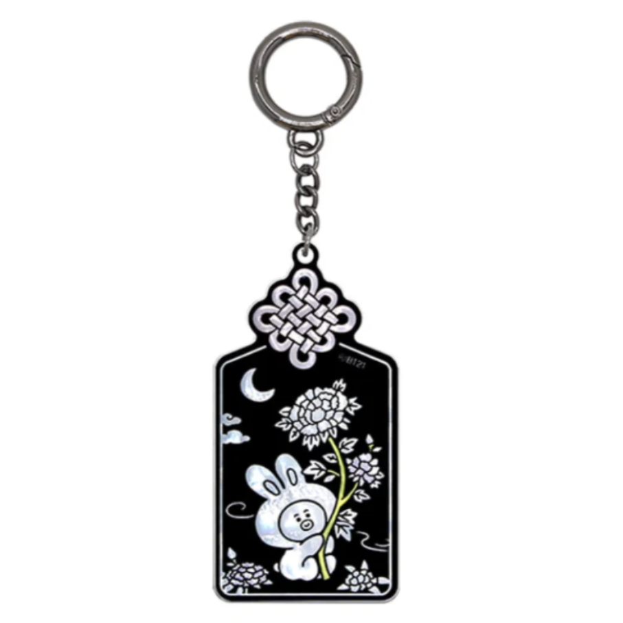 A black enamel keychain tag with a silver-tone metal key ring and chain. The tag features white line art of a rabbit, flowers, a crescent moon, and a Chinese knot design at the top.