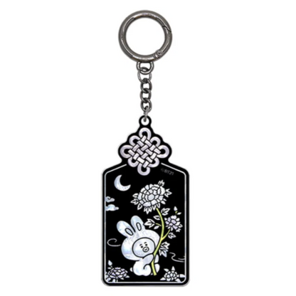 A black enamel keychain tag with a silver-tone metal key ring and chain. The tag features white line art of a rabbit, flowers, a crescent moon, and a Chinese knot design at the top.