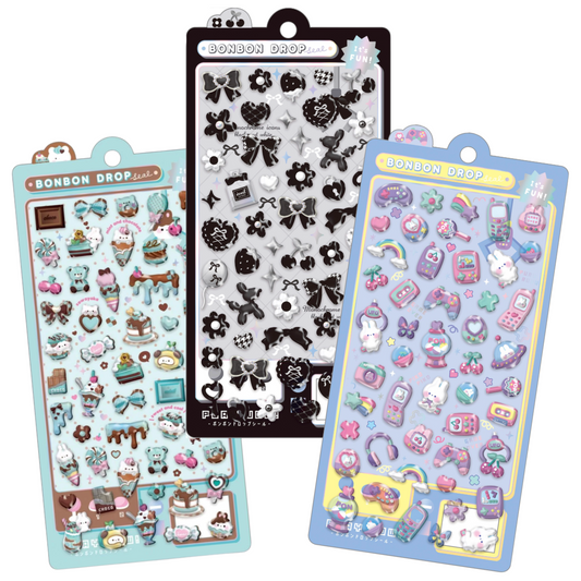 Three Bonbon Drop sticker sheets displayed together on a white background, featuring various cute pastel and black-and-white designs including bows, hearts, flowers, and food-themed stickers.