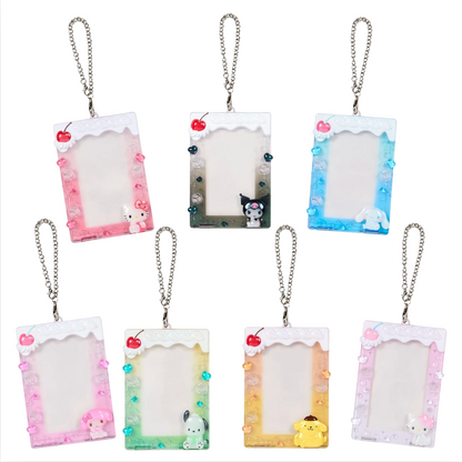Seven acrylic photo frame keychains with silver chains, arranged in a 2x4 grid on a white background. Each frame has a different pastel color scheme and cute character designs including Sanrio characters.