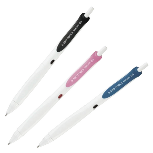 Three white retractable ballpoint pens with black, pink, and blue accents, arranged diagonally on a plain white background. The brand name 'GOOD TOOLS' is printed on the colored bands.